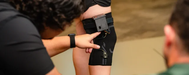 研究人员在膝部袖套上检查动作分析传感器