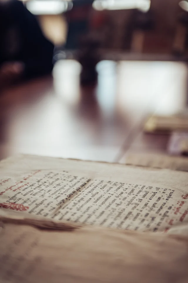 An ancient manuscript opened to pages of cursive handwriting on aged parchment