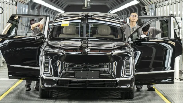 Workers inspect a NIO ES9 electric vehicle on the production line at NIO's Hefei factory