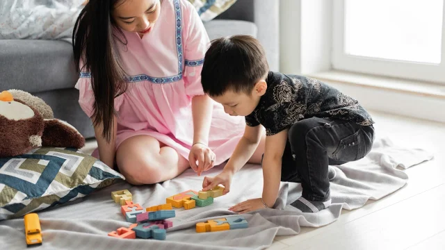 亲子共同玩益智玩具,婦婦在一旁陈列和引导