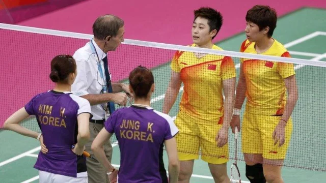A referee speaks to Chinese and South Korean women's doubles players across the net at London 2012.