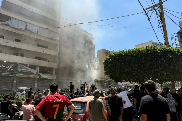 People gather at an Israeli airstrike site in Beirut's southern suburbs