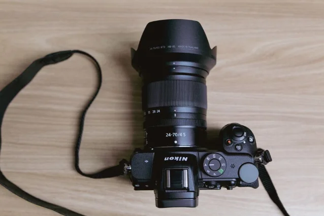 Nikon Z camera body with 24-70/4 S lens, top-down flat lay on wood surface