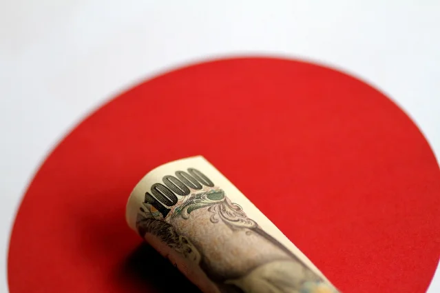 A rolled Japanese 10,000-yen banknote on a red circle