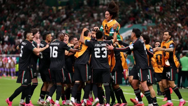 Mexico players celebrate in a group after Luis Romo's winner