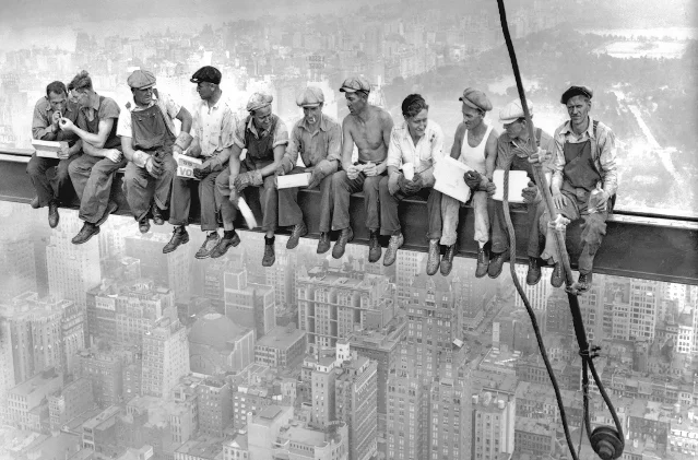 ESB construction crew seated on a steel beam high above Manhattan, 1930s