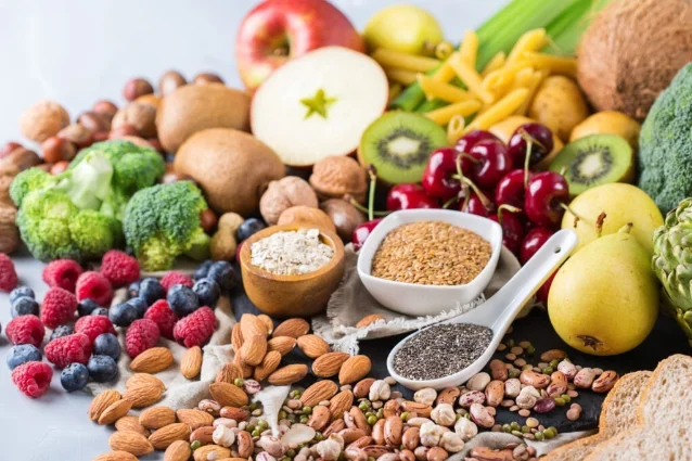 High-fiber foods including berries, nuts, seeds, beans, vegetables, fruit, and whole grains
