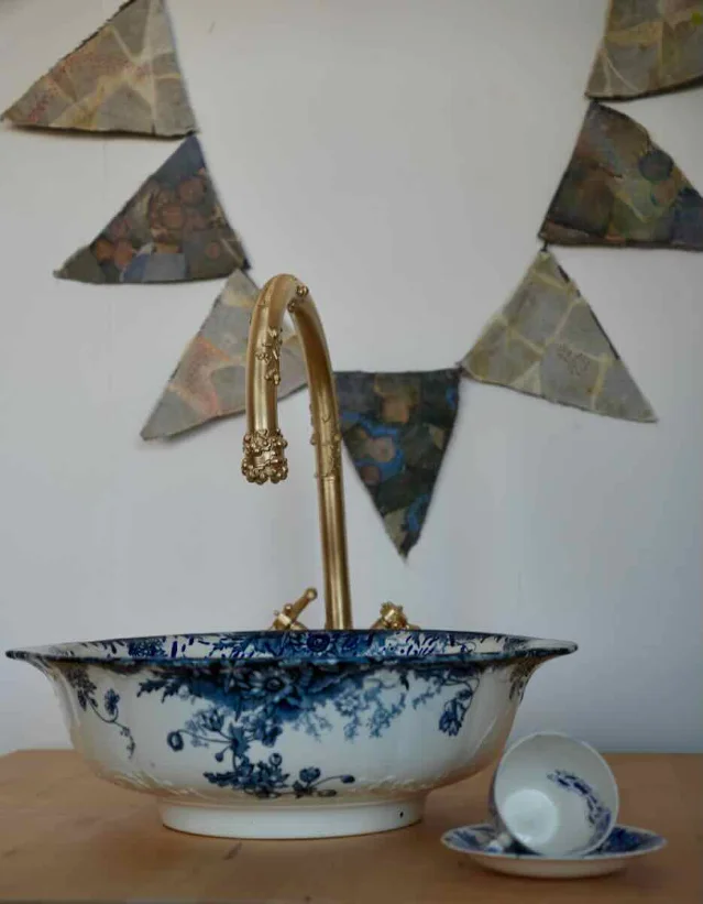 Installation view of Infusoria series showing ceramic painted basins, embroidered bacterial bunting, and altered antique vessels referencing antimicrobial resistance research.