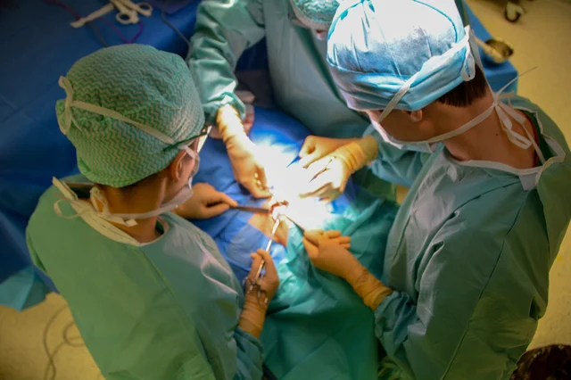 Surgeons performing an operation in a hospital operating room, viewed from above