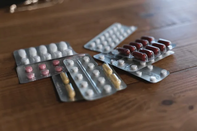Blister packs of pharmaceutical pills on a wooden surface