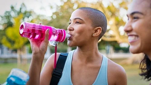 A person drinking from a reusable water bottle
