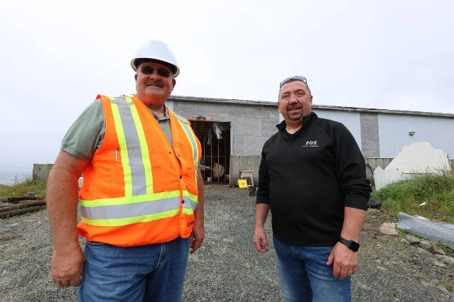 Steve Ryan and Glenn Sharp stand outside the abandoned fish sauce factory in St. Mary's.