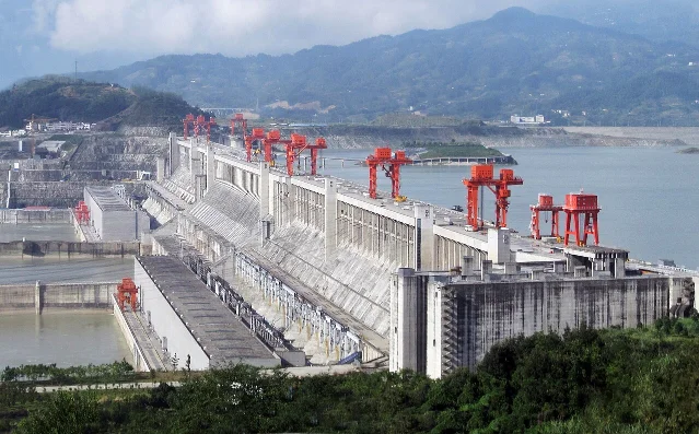 The Three Gorges Dam in September 2009, showing the full concrete gravity structure, open spillway bays, and the Yangtze River downstream
