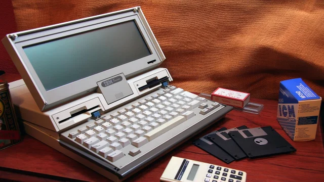 一台来自 1990 年代的复古 IBM 个人电脑，配有软盘和老式键盘，象征 GeoCities 年代的手工互联网