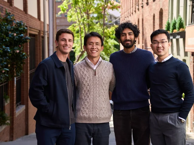 Four men standing together on a city street