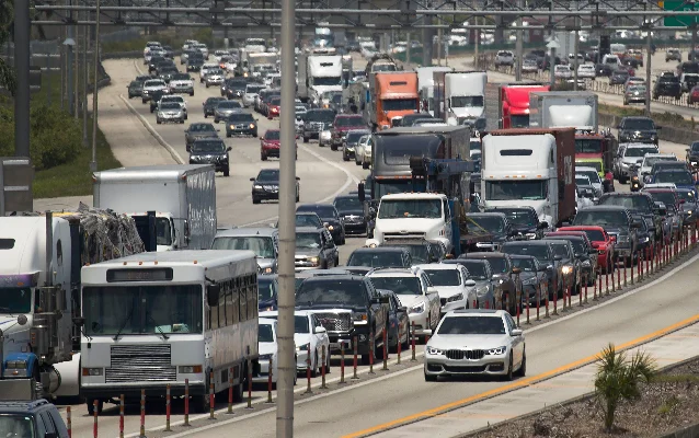Cars and trucks moving in heavy traffic on a multi-lane American highway