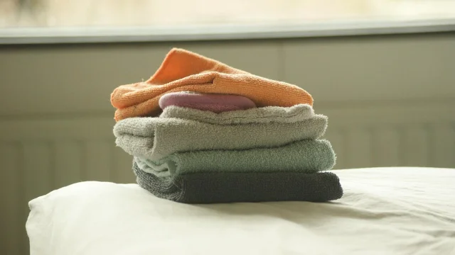 A neat stack of folded towels on a bed