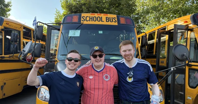 Scotland fans stand in front of a rented yellow school bus