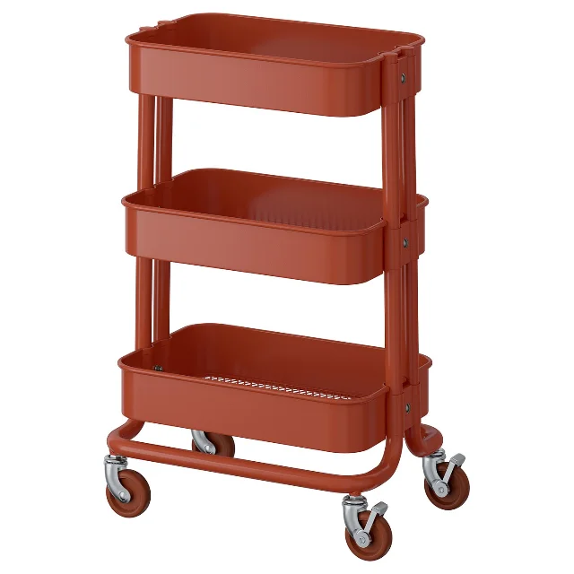 Official IKEA image of the red-brown RÅSKOG trolley with three shelves and casters.
