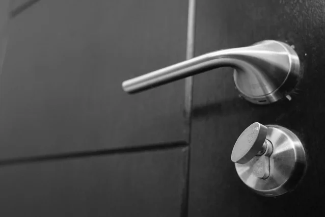 Close-up of a stainless steel door lever and lock mechanism, showing the material grade relevant to CE-rated hardware