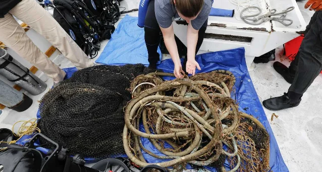 Recovered fishing nets and rope are sorted on the boat.