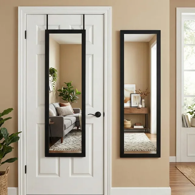 A black-framed full-length mirror hanging over a white interior door in a bright room.