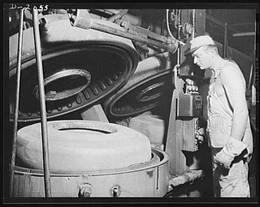 Factory worker operating a tire vulcanization mold, 1941