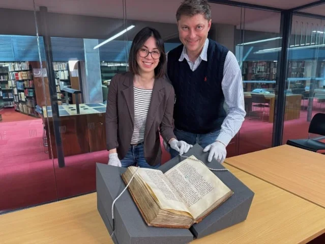 Dr Elisabetta Magnanti 与 Dr Mark Faulkner 在三一学院图书馆查阅贝德手稿