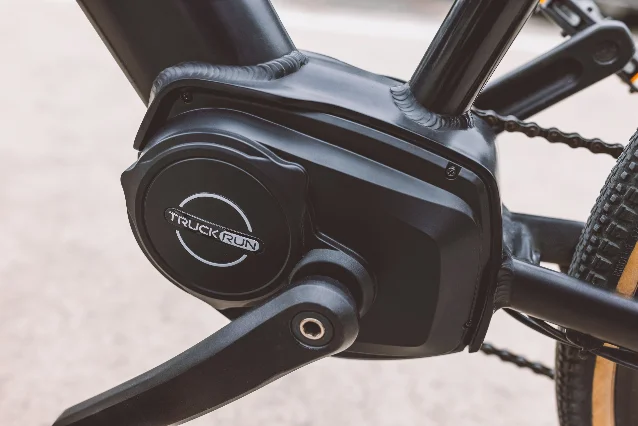 Close-up of a mid-drive motor mounted at the bottom bracket of a black eBike