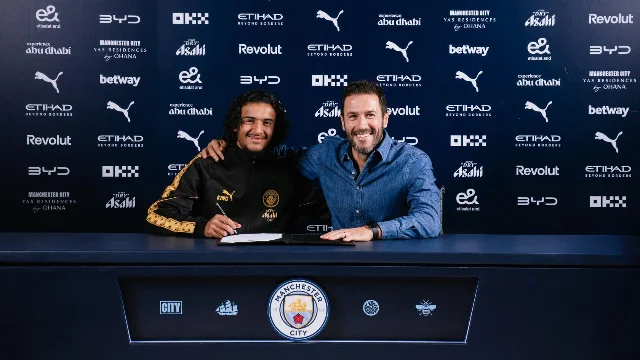 Ayyoub Bouaddi signs his Manchester City contract beside a club official