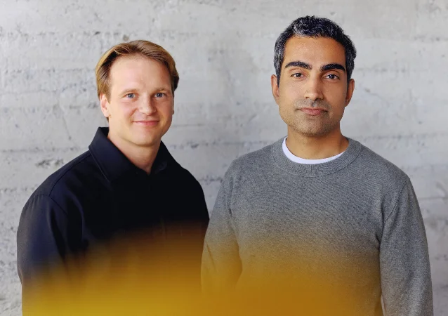 Rune Kvist and Rajiv Dattani, co-founders of AIUC, photographed against a concrete wall