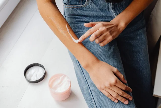 Person applying cream to arm in a body care skincare routine