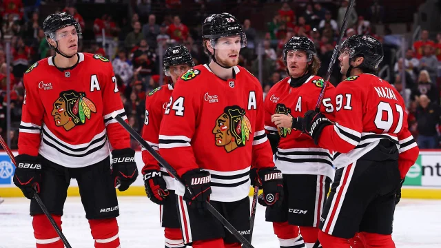 Chicago Blackhawks players grouped on the ice during a home game