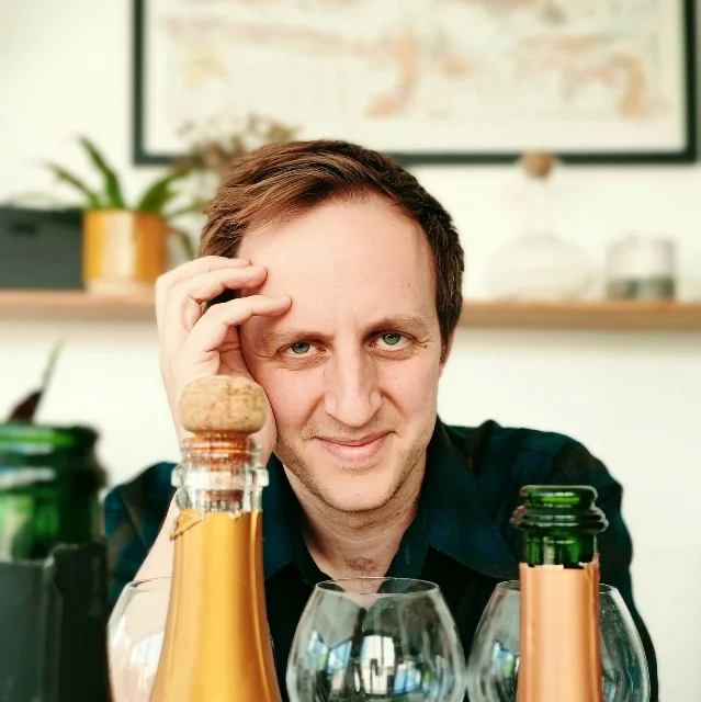 Tom Hewson photographed outdoors in a vineyard setting