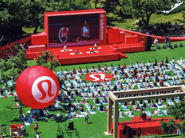 lululemon 长城瑜伽嘉年华现场航拍,大批习练者在草坪上跟随红色舞台的指引练瑜伽