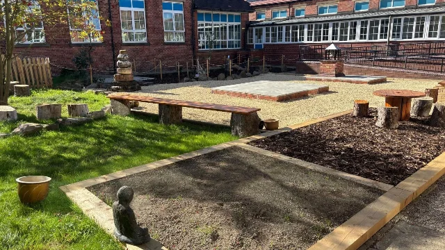 The rebuilt quad at The Hill Primary Academy in Thurnscoe, with gravel walkways, wooden benches, planting beds and a small seated statue