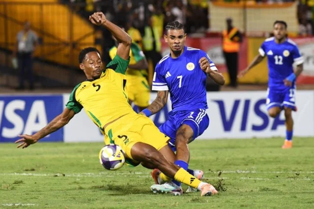 Curaçao's Juninho Bacuna challenges Jamaica's Ethan Pinnock during the decisive qualifying match