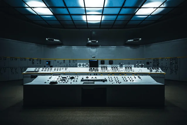 A government-style control room with multiple monitors and a control panel, symbolizing regulatory oversight of AI systems