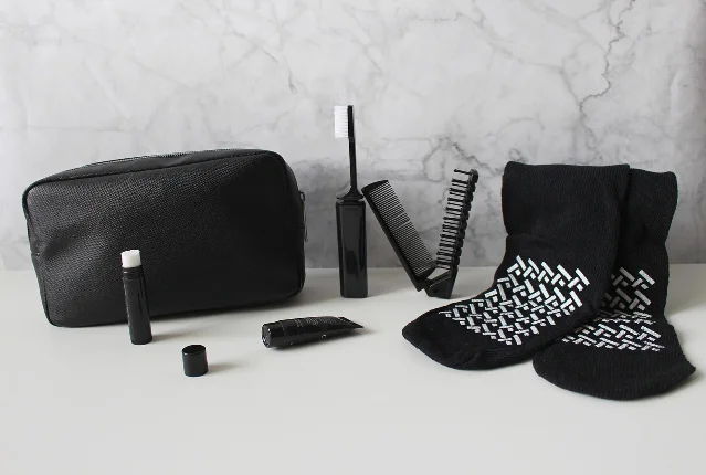Open travel toiletry bag with bottles, toothbrush, razor, and comb