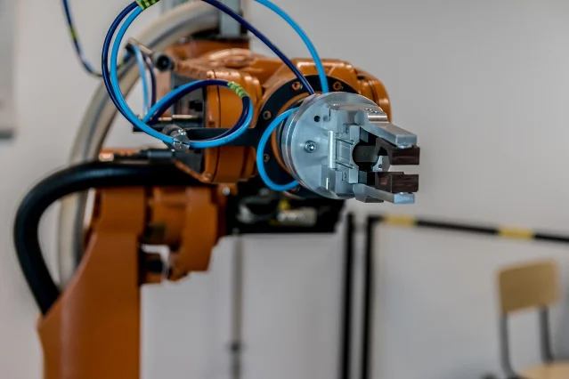 Industrial robotic arm performing a programmed task — the type of physical-world systems WLAM is designed to plan for