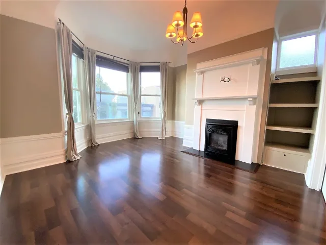 959 Union St #961 living room — arched bay window, yellow pendant light, black gas fireplace, dark hardwood floors