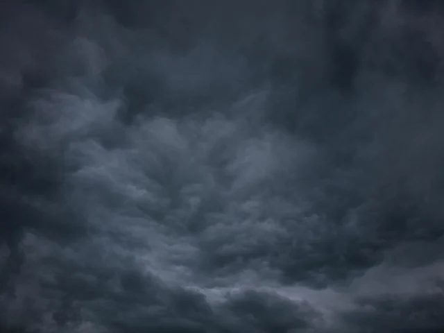 Dark storm clouds gather over a landscape