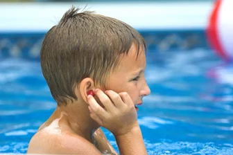 Swimmer putting in ear plugs