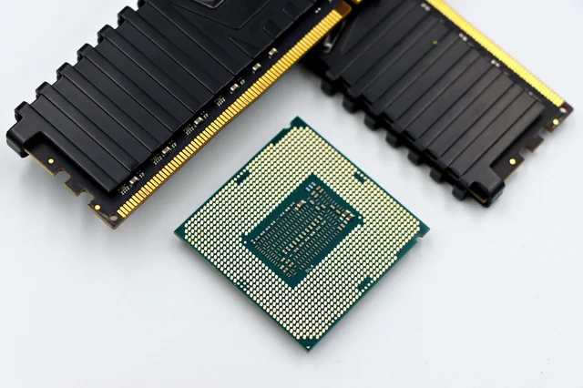 CPU and RAM memory modules on clean white surface, representing the memory cost crisis hitting Apple's iPhone supply chain
