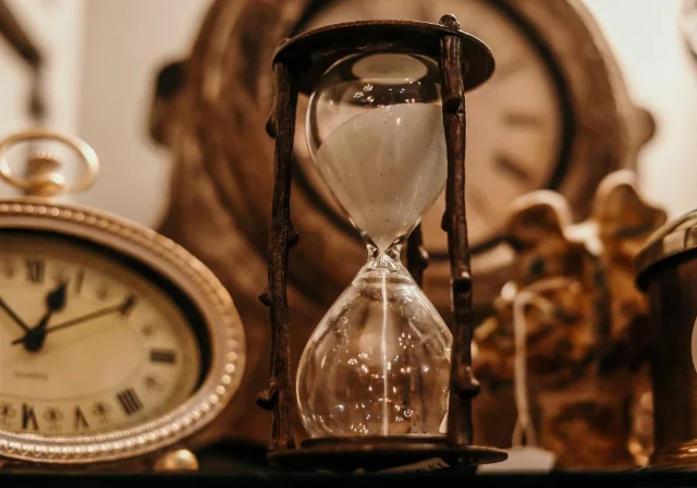 An hourglass and vintage clock on a table, evoking the time pressure of near-expiry offer deadlines