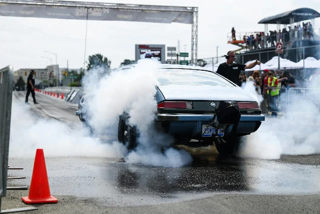 Classic drag car performing a burnout through thick tire smoke at Roadkill Nights