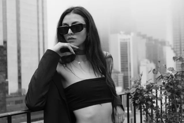 Monochrome portrait of a woman in tube top and sunglasses, urban setting