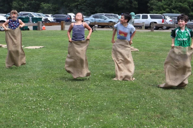 Children compete in sack races on the grass