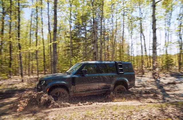 A 2024 Land Rover Defender 130 Outbound photographed on a gravel track