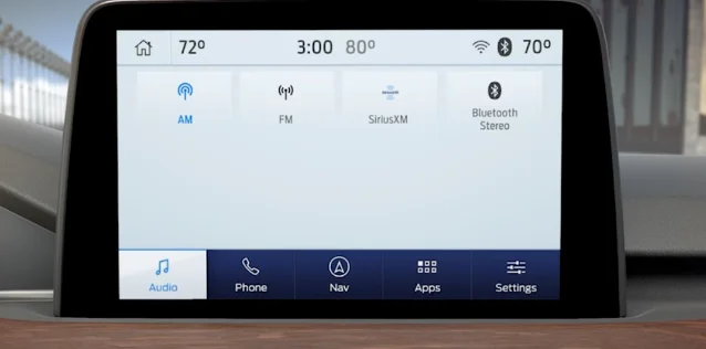 A car infotainment touchscreen showing an audio source menu with AM, FM, SiriusXM and Bluetooth listed